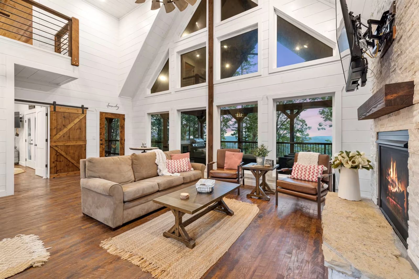 Vaulted great room with a wall of windows and a fireplace.